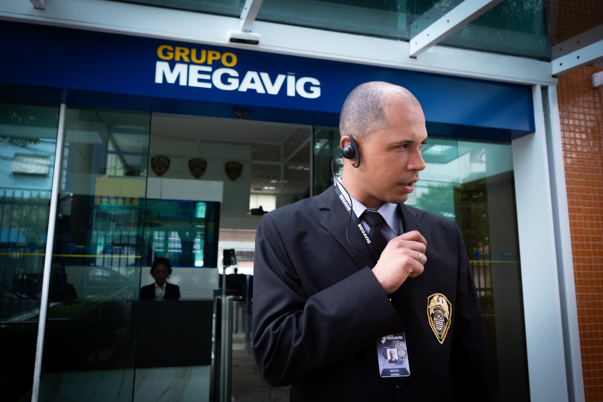 Profissional da Megavig com rádio e crachá em portaria de condomínio com controle de acesso